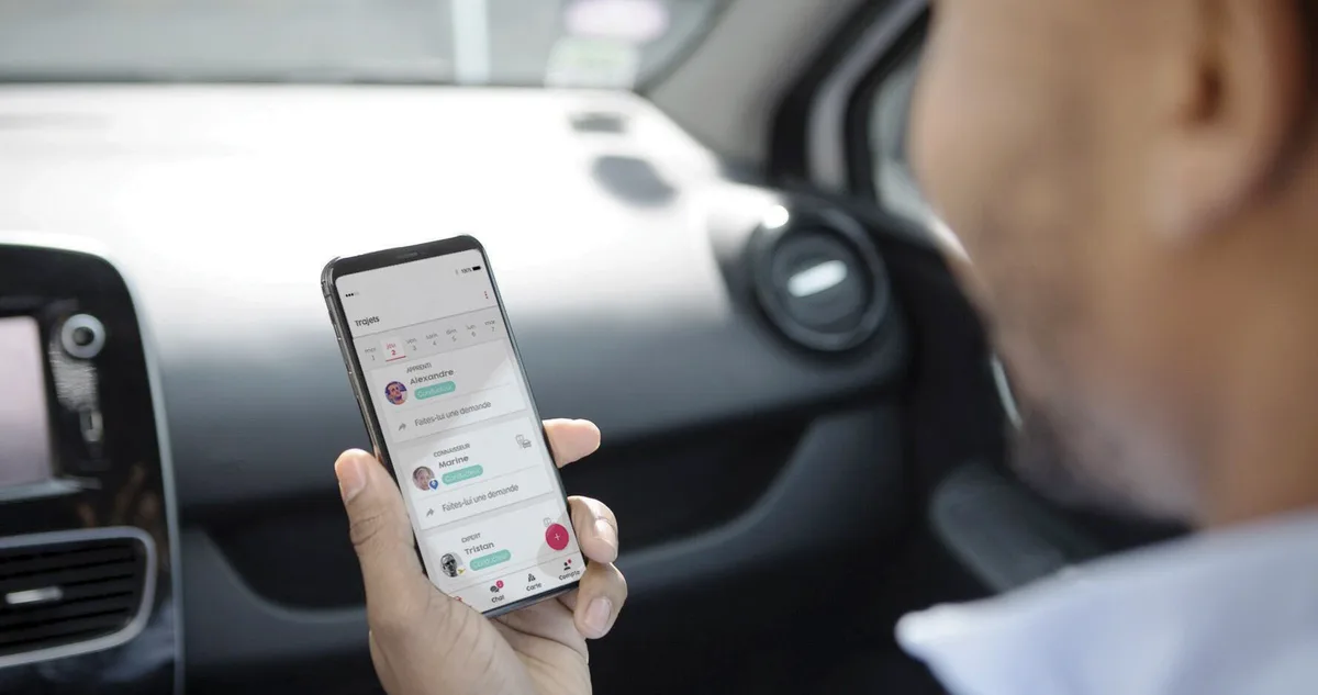 Passager assis à l’arrière d’une voiture consultant une application de covoiturage sur son smartphone