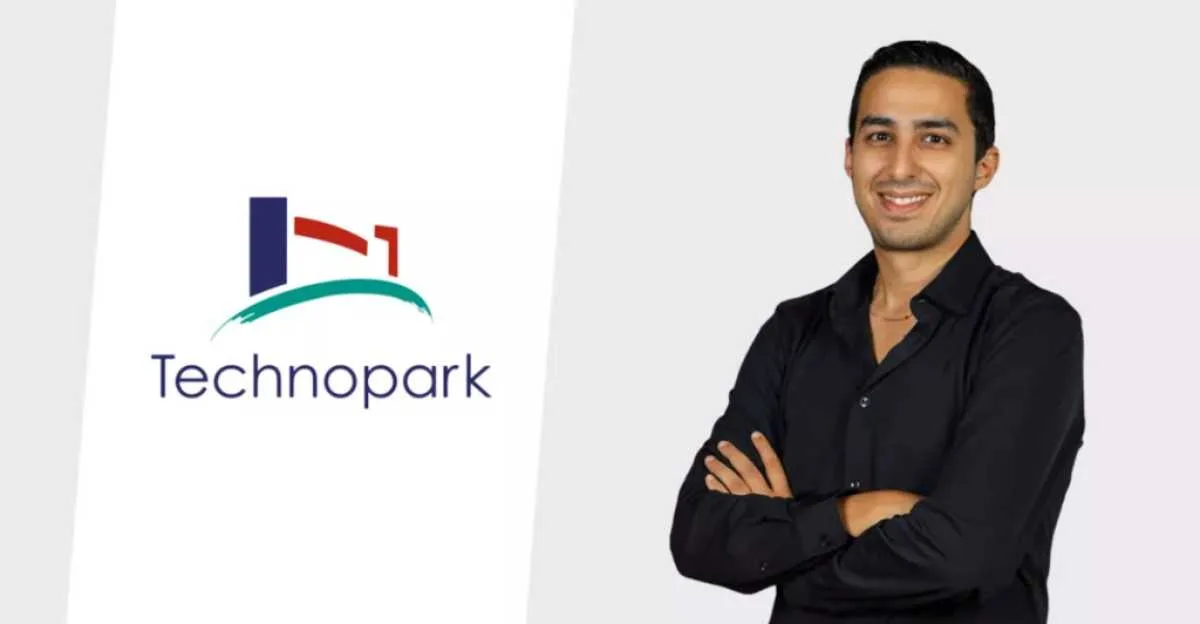 Hicham Zouaoui, bras croisés, à côté du logo du Technopark